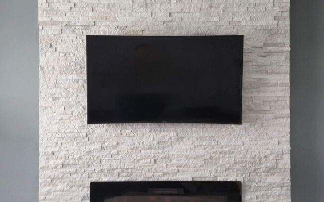 IQHome professional installation of TV, fireplace, and decorative stone in Toronto living room.